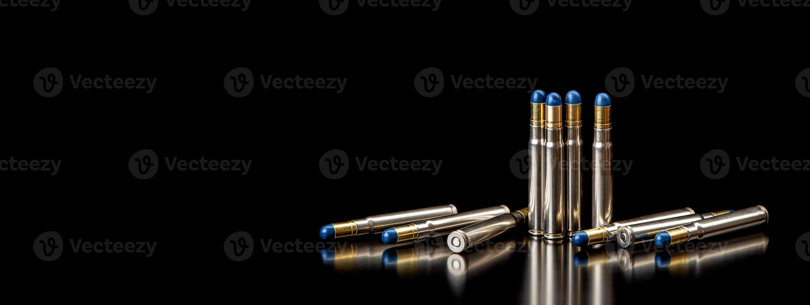 Bullet isolated on black background with reflexion. Rifle bullets close-up on black back. Cartridges for rifle and carbine on a black. photo