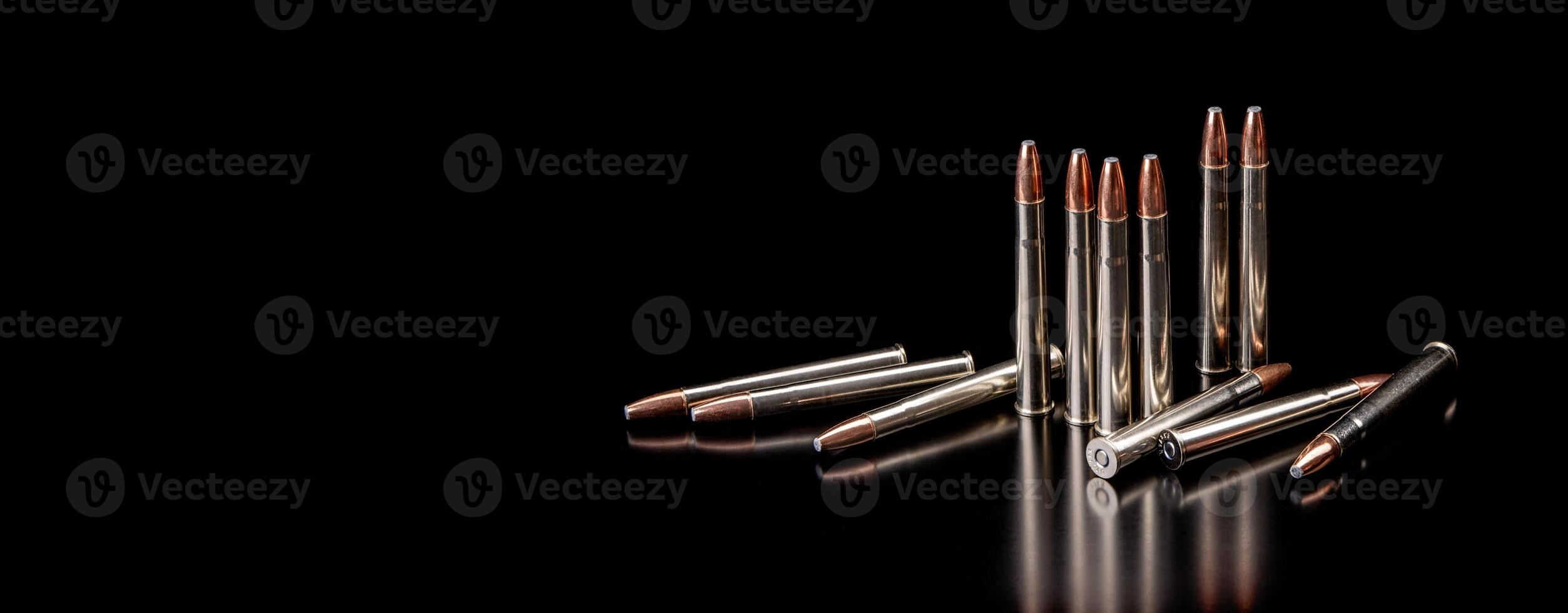 Bullet isolated on black background with reflexion. Rifle bullets close-up on black back. Cartridges for rifle and carbine on a black. photo