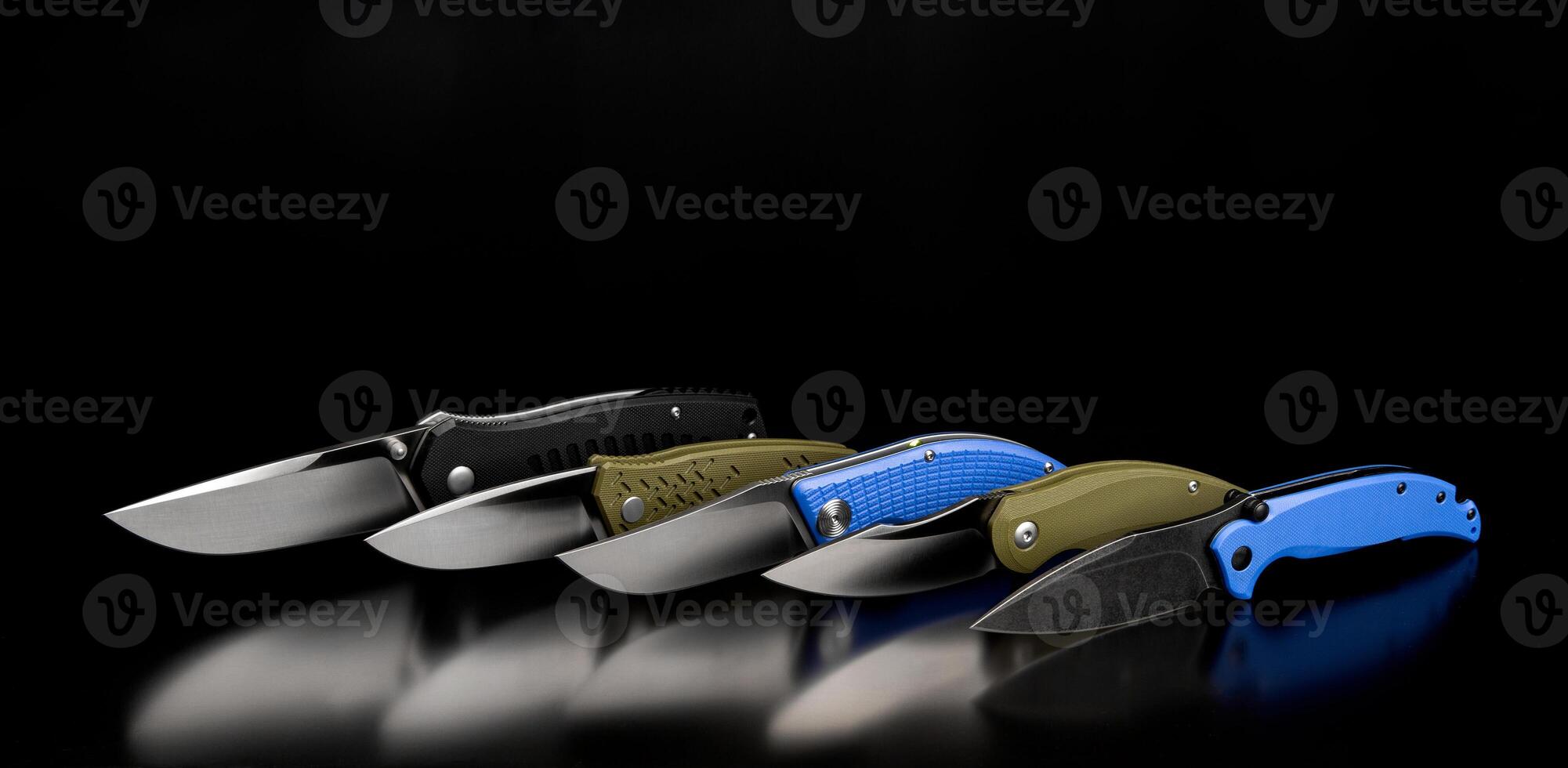 folding knives on a black background. pen knives on a dark back photo