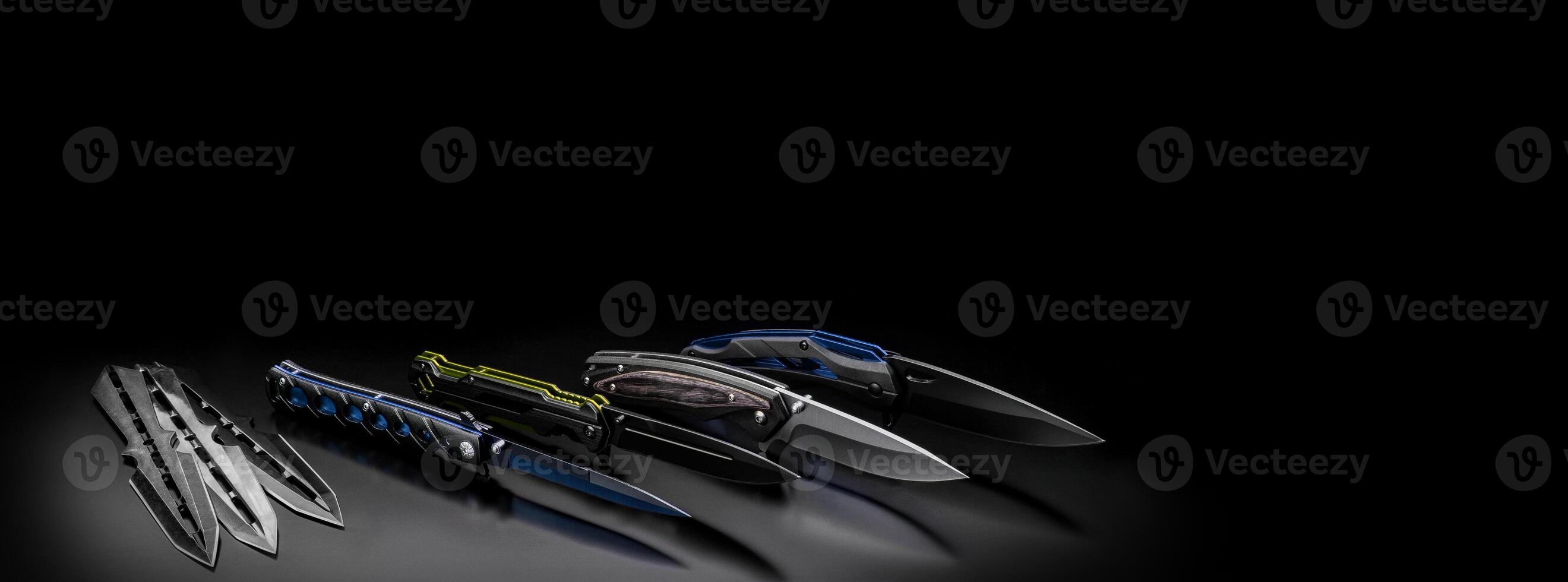 folding knives on a black background. pen knives on a dark back photo