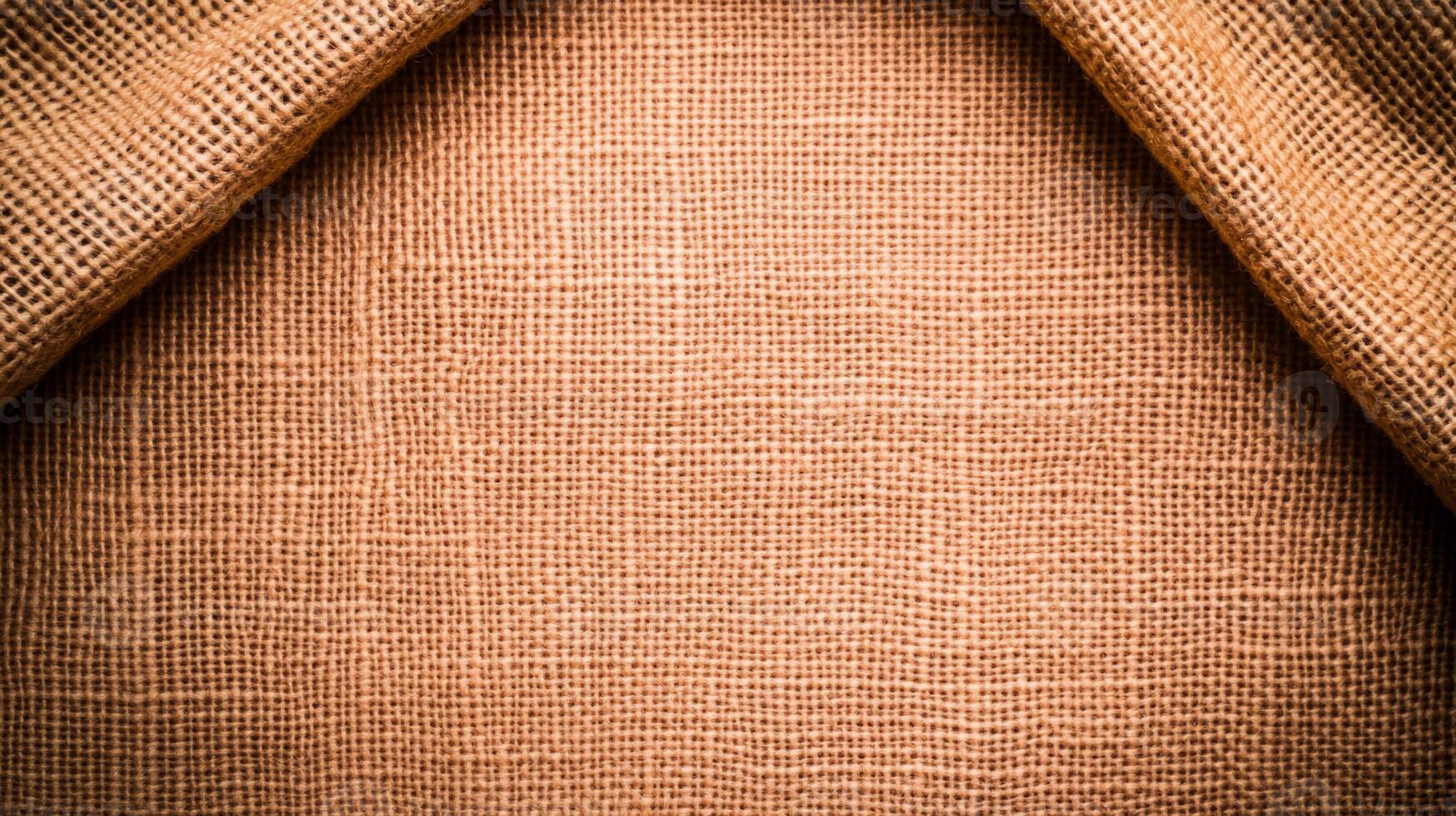Rough burlap texture with subtle orange and brown tones perfect for Thanksgiving backgrounds autumn vibes emphasized by rustic weave pattern photo