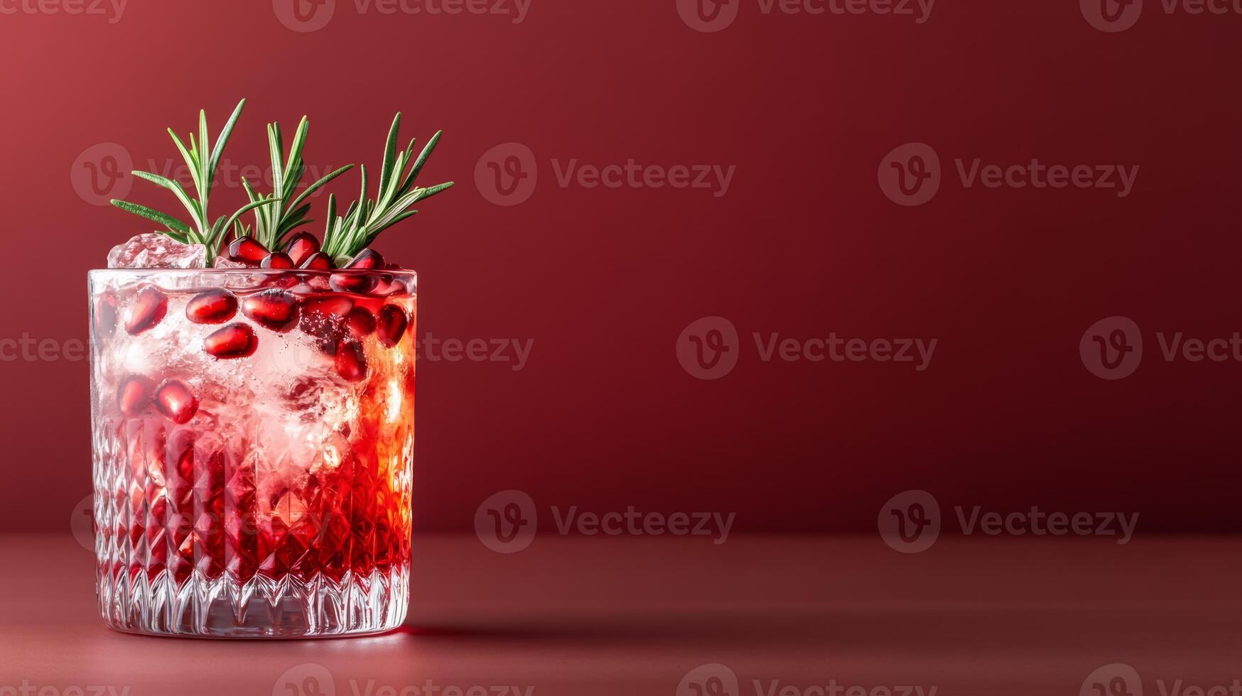 Spiced pomegranate cocktail with gin and tonic, garnished with fresh pomegranate seeds and rosemary, rich colors against a gradient background from dark red to soft gold photo