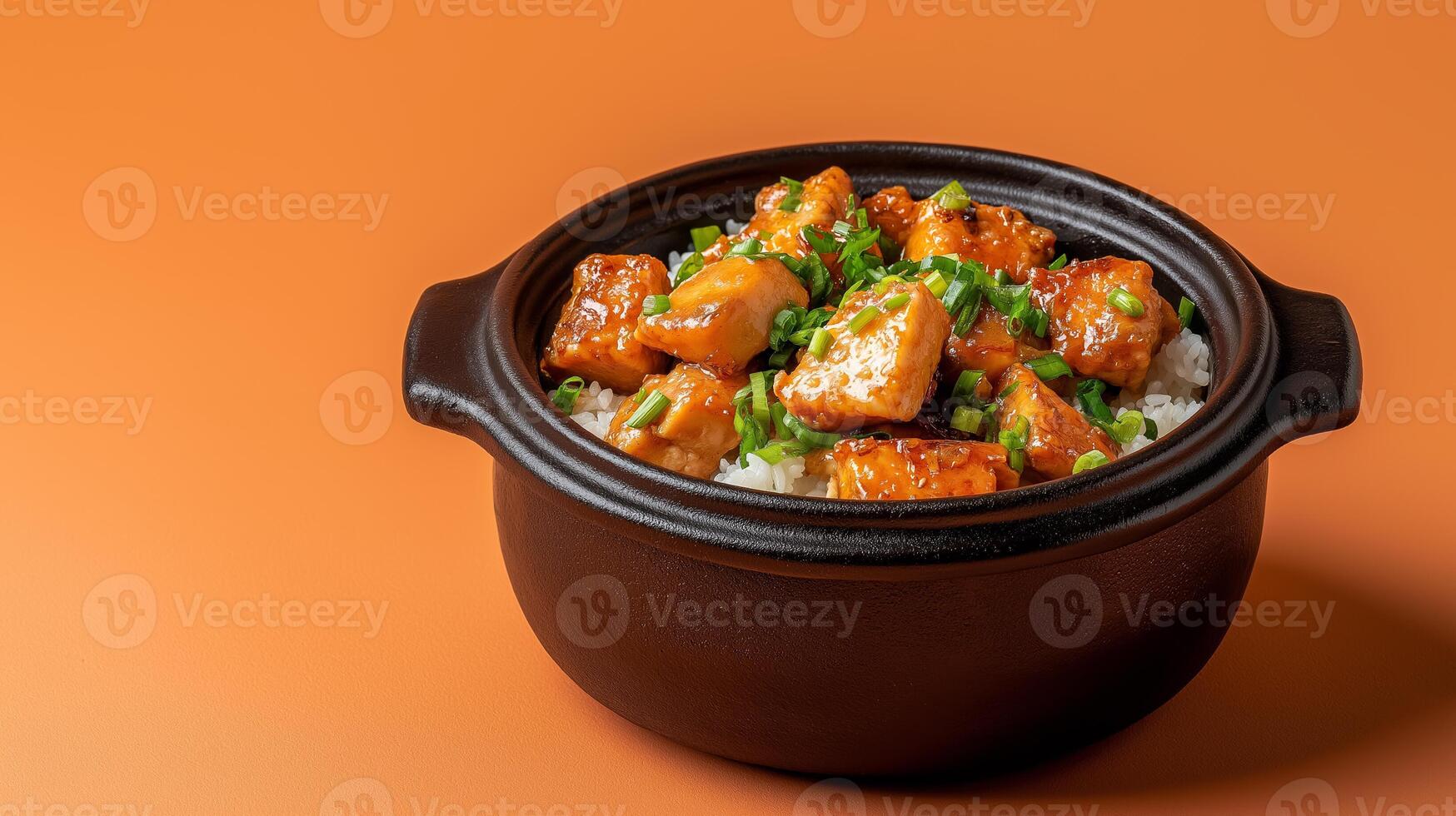Vietnamese autumn dish of caramelized claypot fish with ginger and green onions, served with warm rice, set on a gradient background fading from deep orange to brown photo