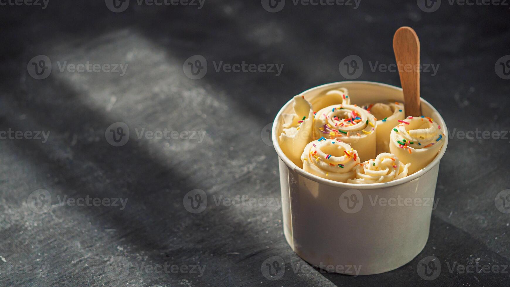 Rolled ice cream in cone cup on dark,copy space photo