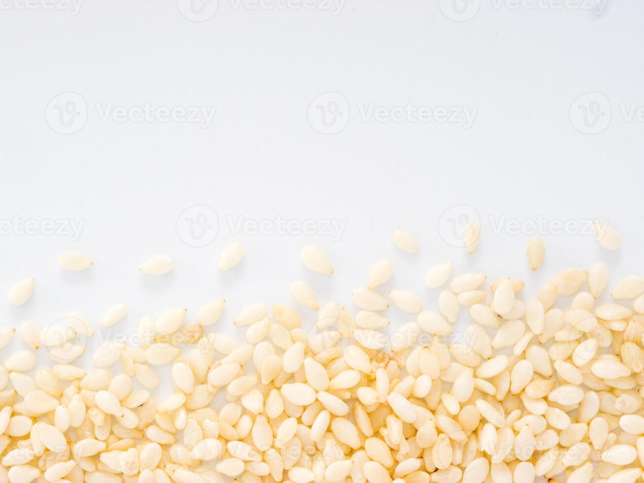 Sesame Seeds on white background with copy space. Isolated one edge. Top view or flat lay. photo