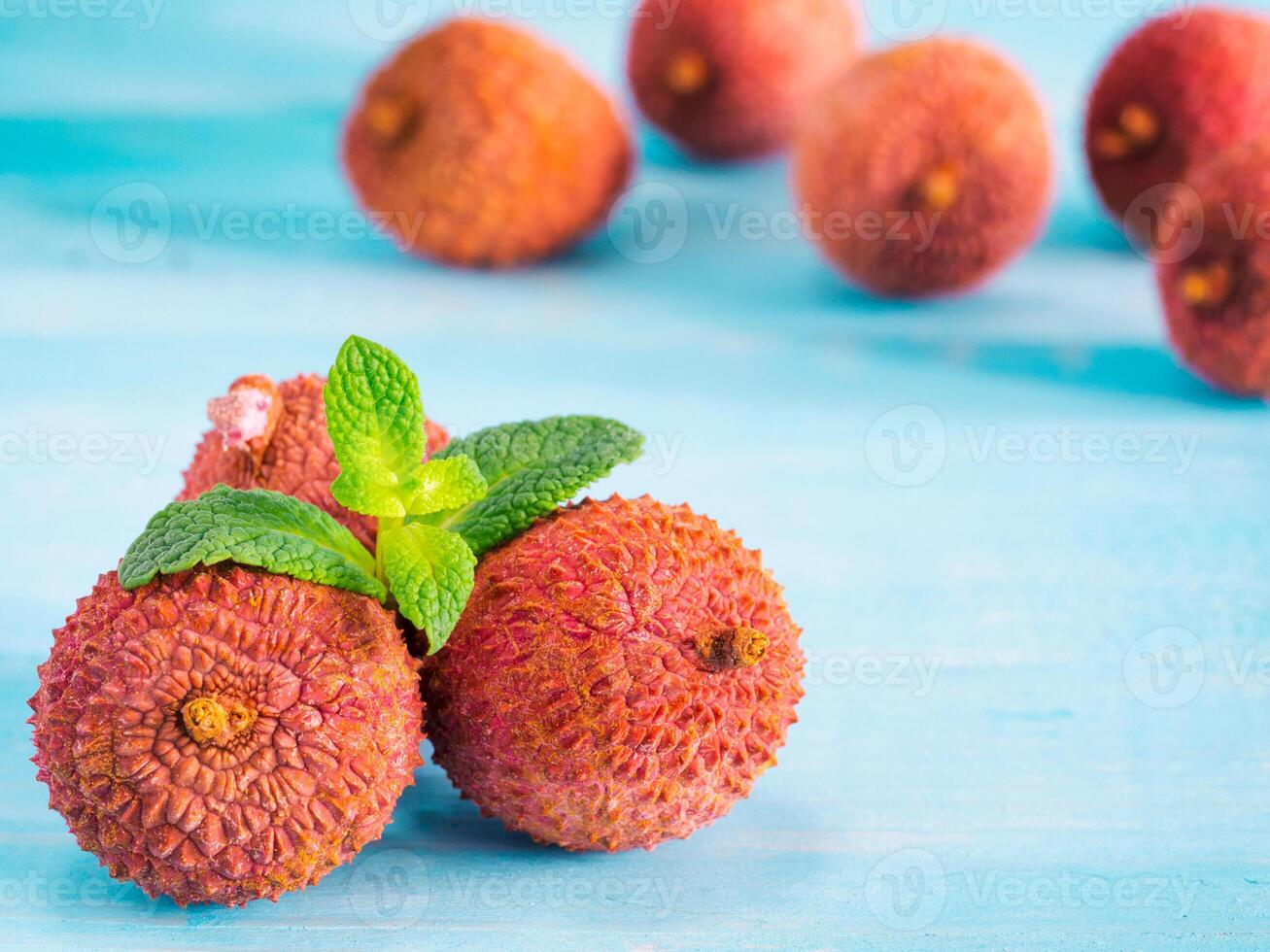 lichee fruit on turquoise wooden background close up photo