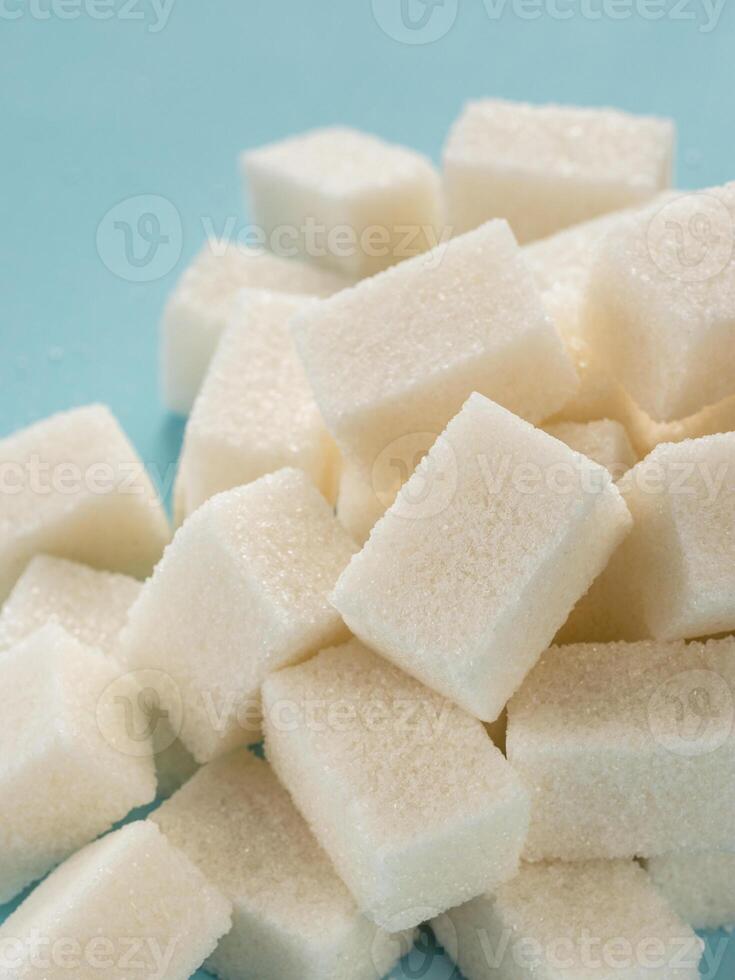 Background of sugar cubes. White cube sugar on blue background. White sugar close up photo