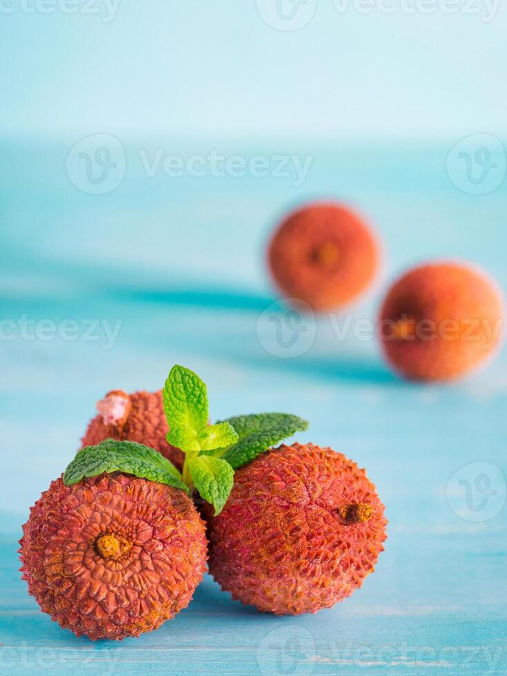 lichee fruit on turquoise wooden background close up photo