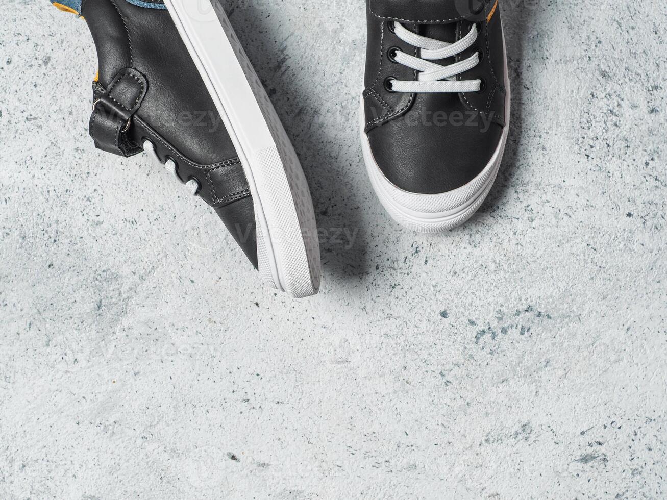 Gray and yellow sneakers on gray background photo