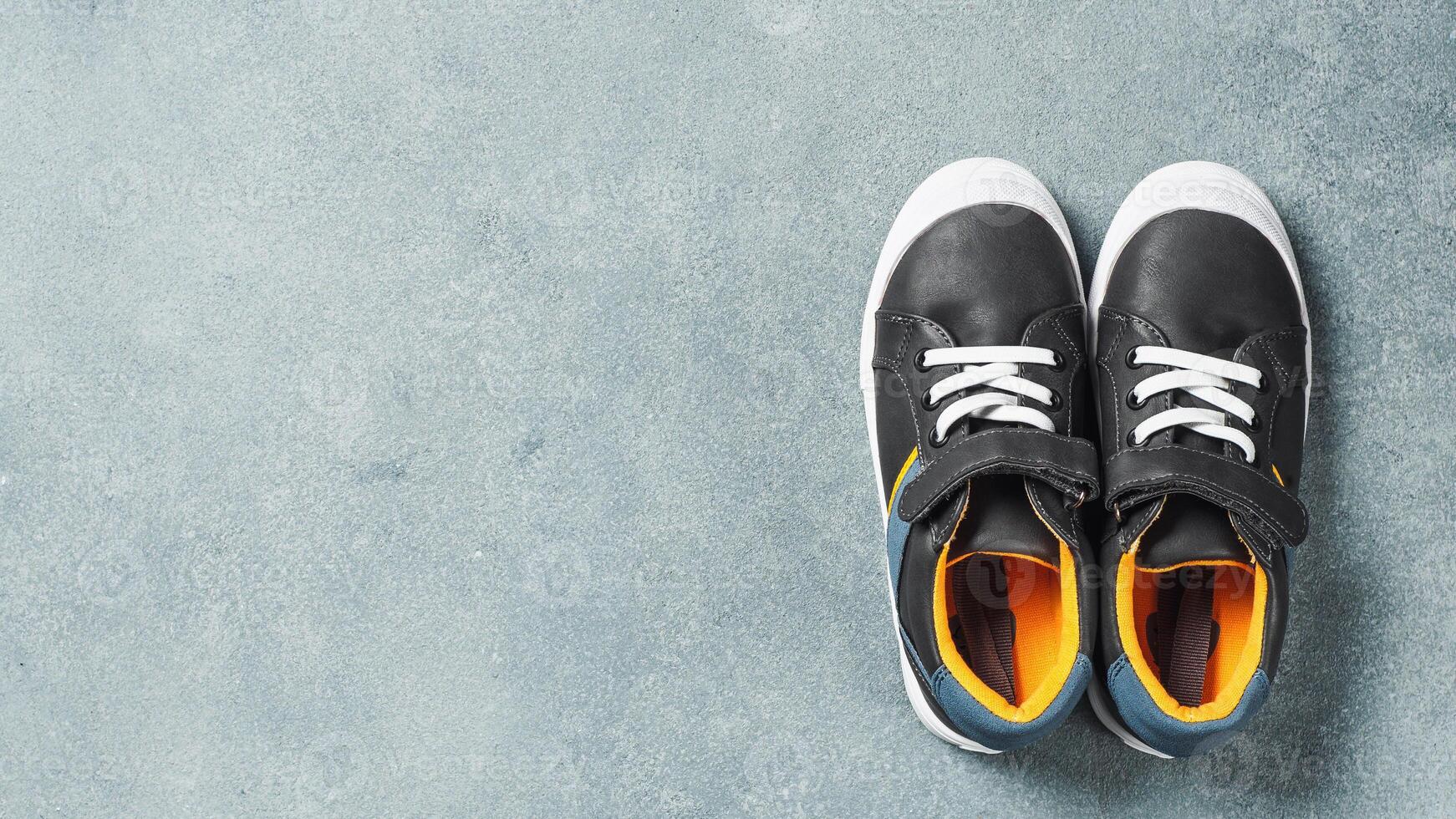 Gray and yellow sneakers on gray background photo