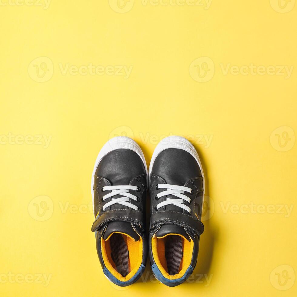 Gray and yellow sneakers on yellow background photo