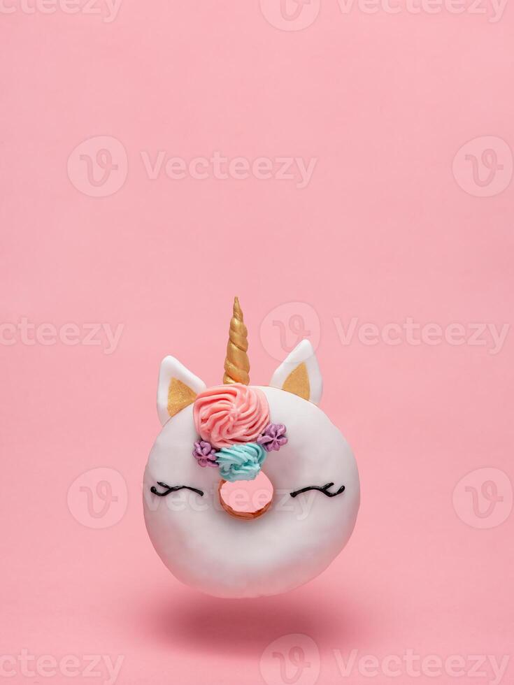 Unicorn donut flying, pink background, copy space photo