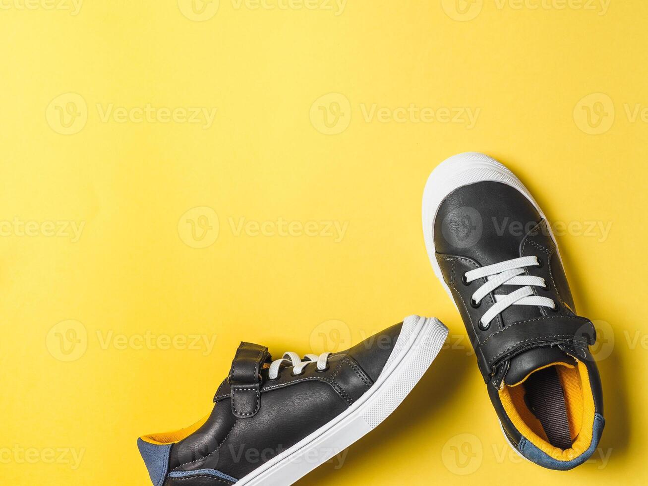 Gray and yellow sneakers on yellow background photo