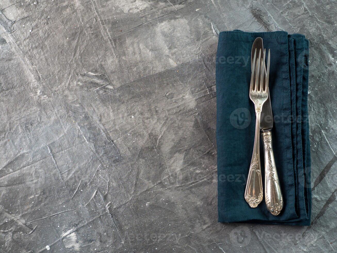 Cutlery on emerald linen napkin, copy space photo