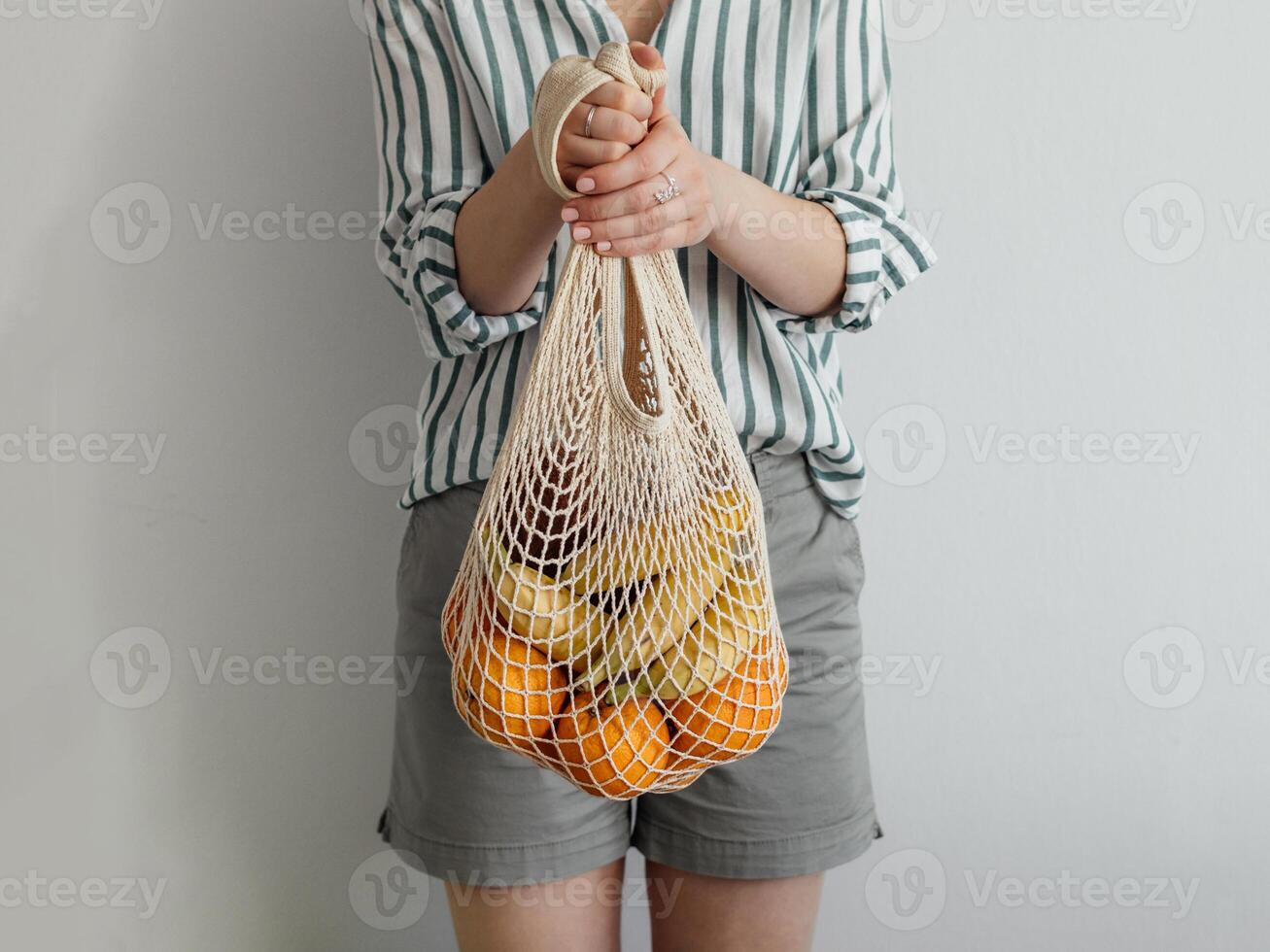 woman standing with mesh bag in hands photo