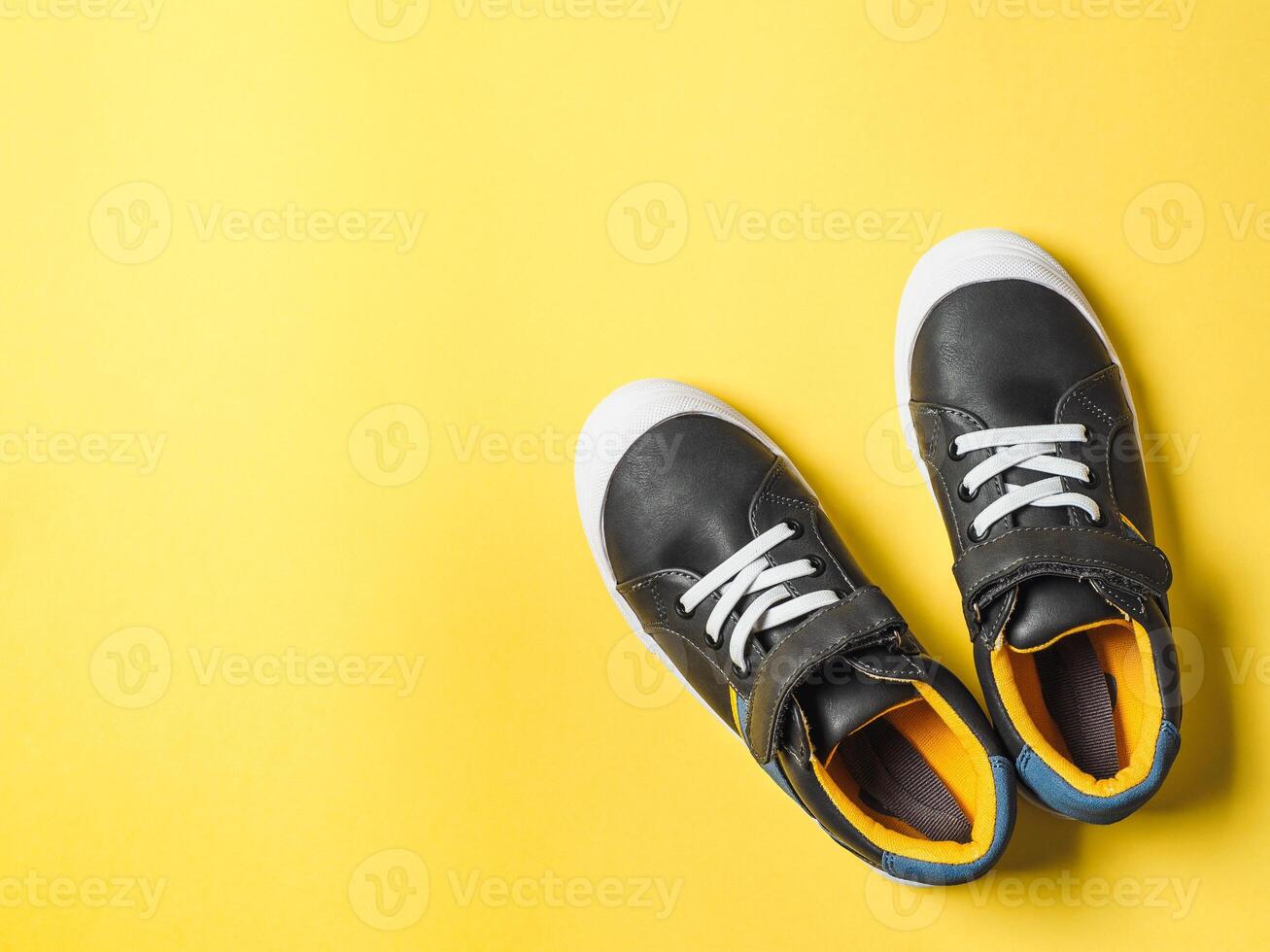 Gray and yellow sneakers on yellow background photo