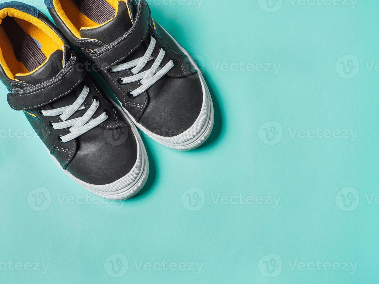 Gray and yellow sneakers on blue background photo