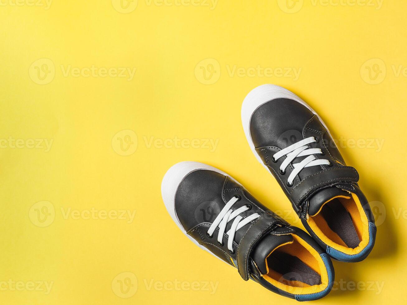 Gray and yellow sneakers on yellow background photo