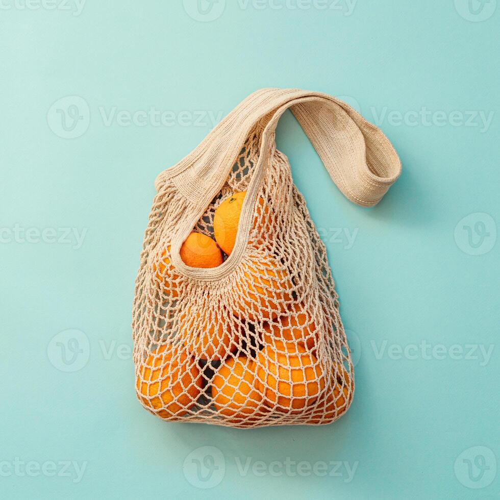 Mesh bag with fruits on blue background.Zero waste photo