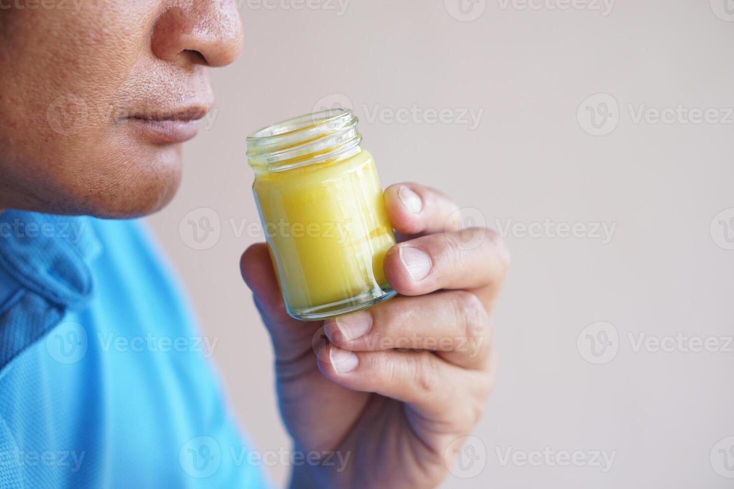 Close up man holds bottle of yellow balm to smell to relieve dizzy ,headache, emotional stress symptoms. Concept, healthcare. Thai local wisdom to use fragrant herbs to mix in ointment to therapy. photo