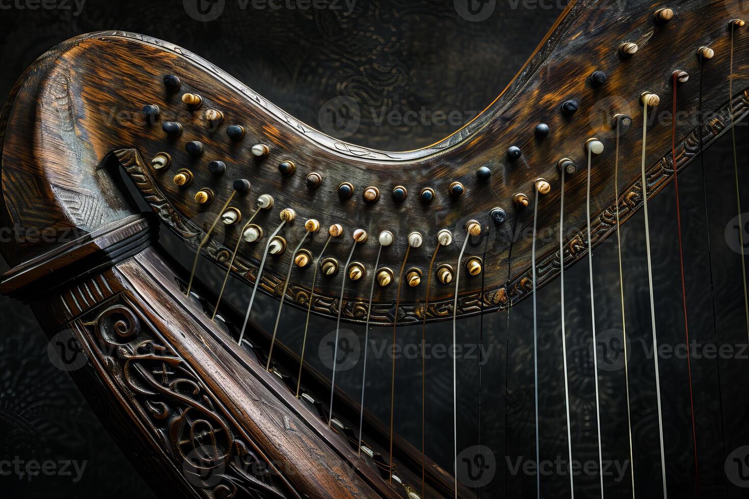 Antique celtic harp made from dark wood showing tuning pins and strings photo