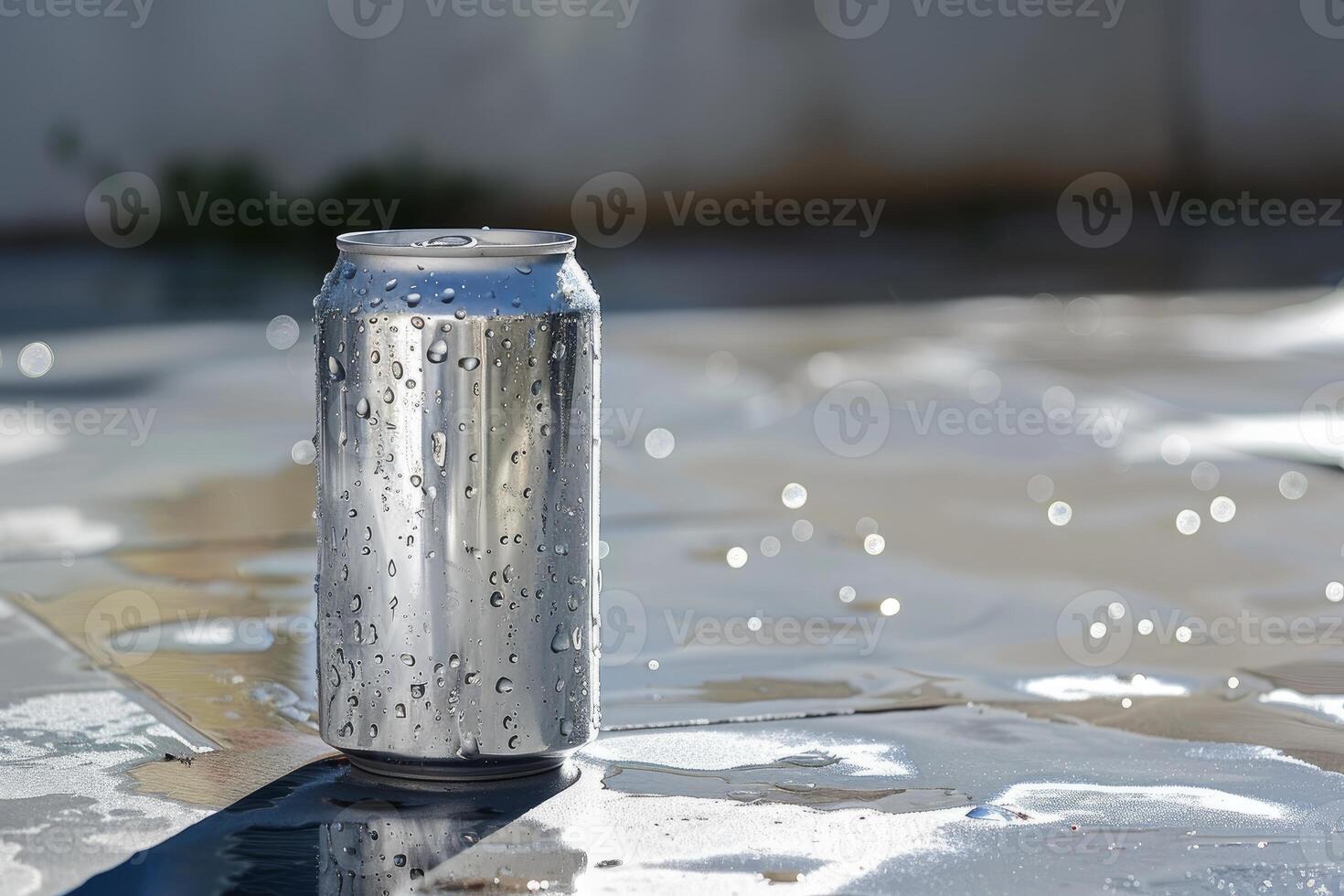 Aluminum can covered with condensation resting on wet surface photo