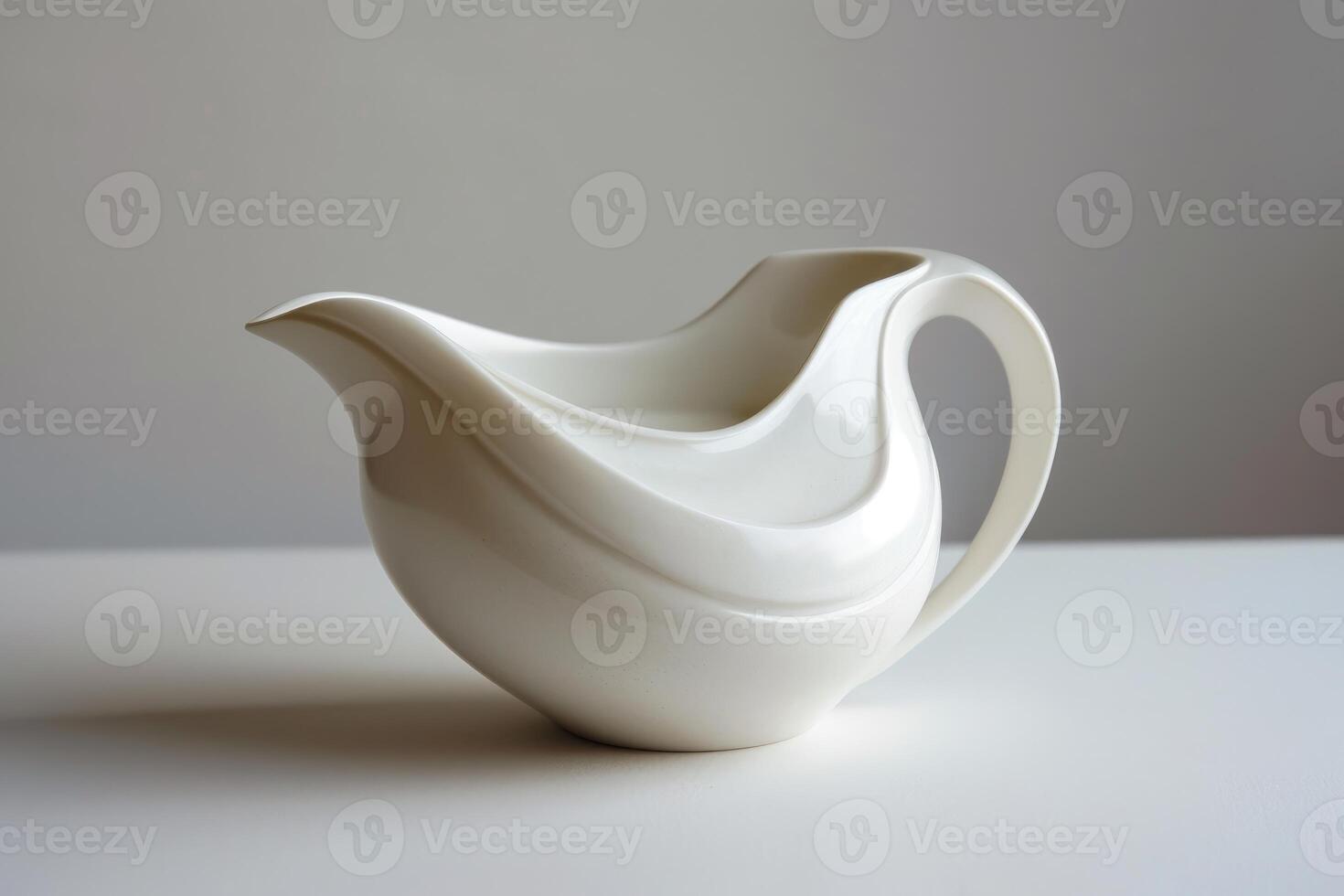 White minimalist porcelain sauce boat standing on white table photo