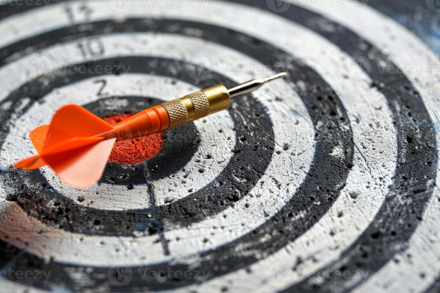 Orange dart hitting the center of target on black and white dartboard photo