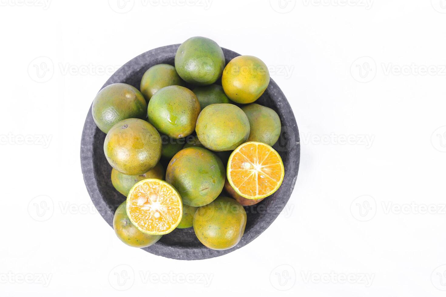 Green orange fruit or Tangerine orange with half slice and green leaves in Traditional Mortar isolated on white background. top view. photo