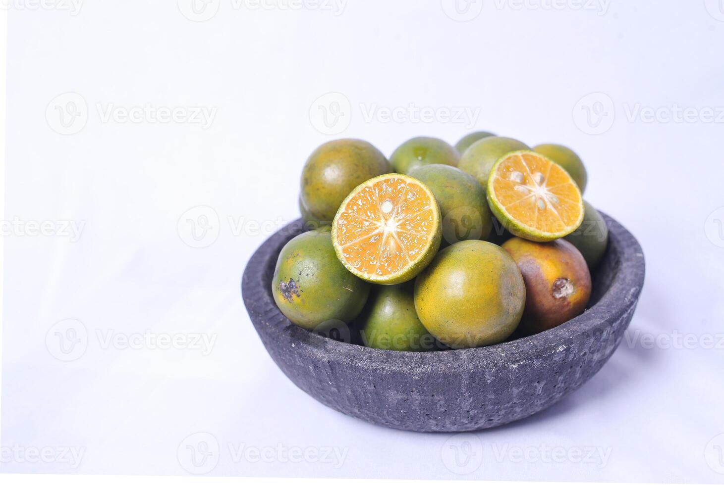 Green orange fruit or Tangerine orange with half slice and green leaves in Traditional Mortar isolated on white background. side angle. photo