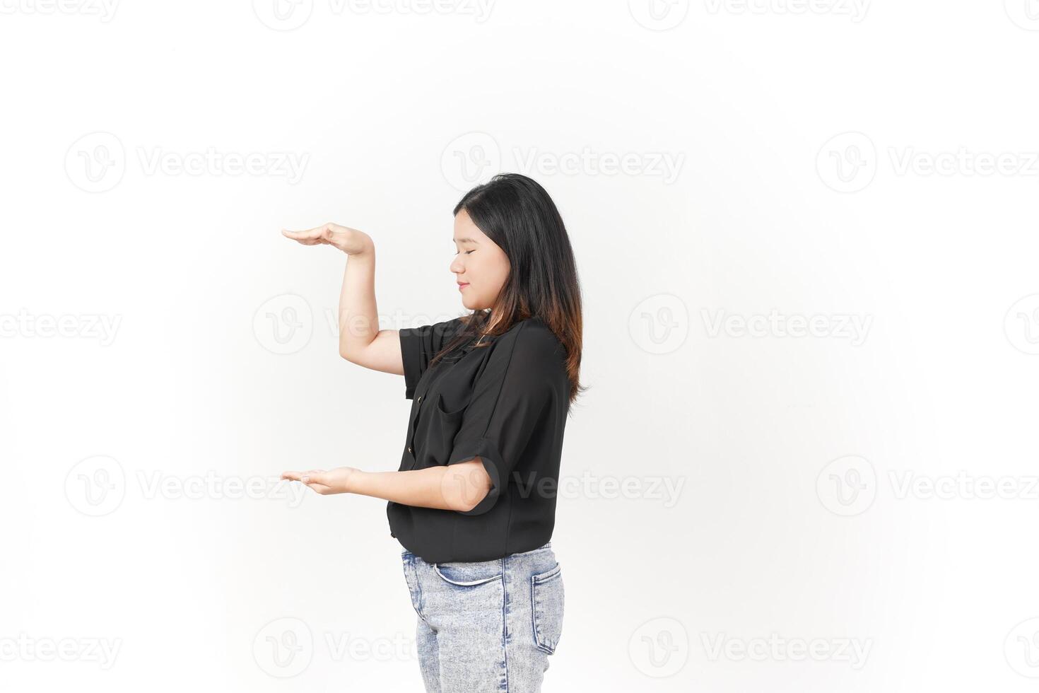 Young Asian woman Measuring and Showing Big Product wearing Black t-shirt and jeans isolated on white background photo