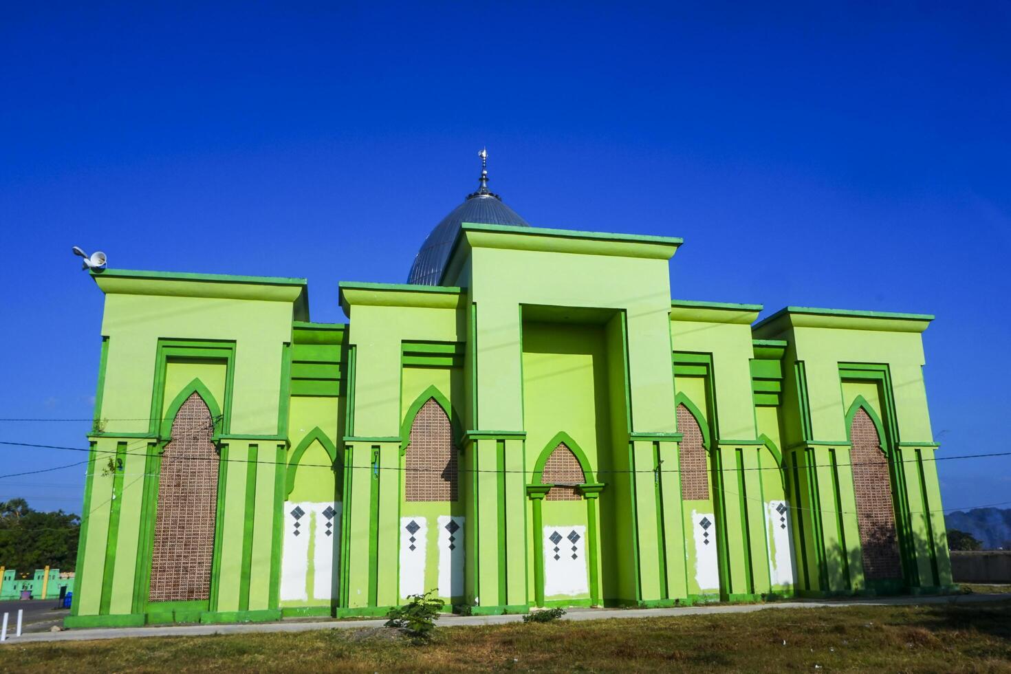 Photo of a magnificent green mosque under a blue sky
