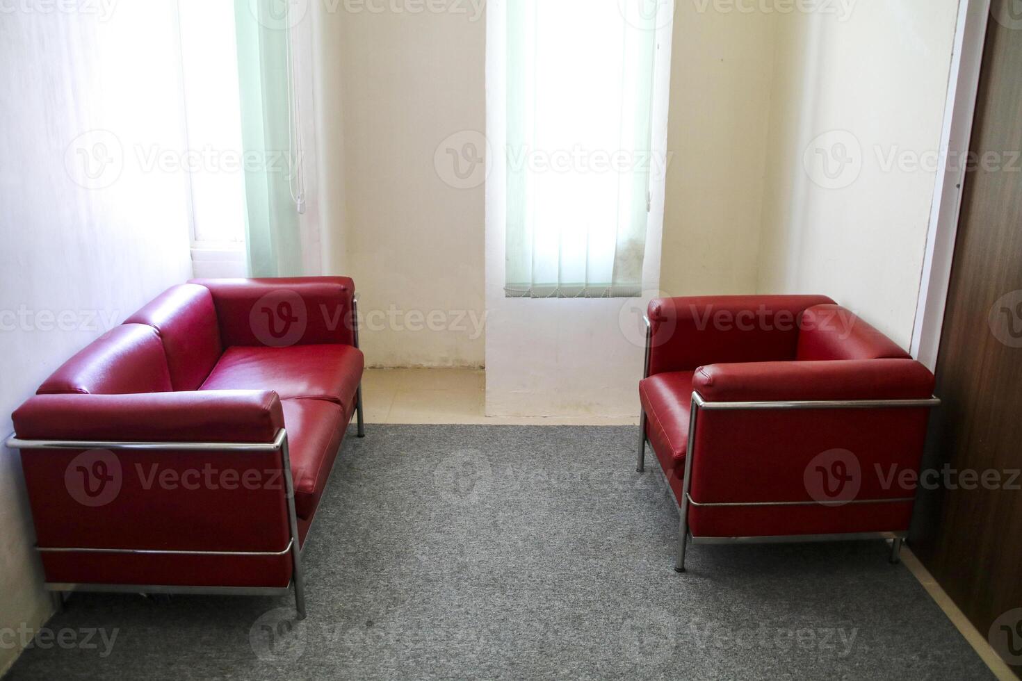 The red sofa is opposite in the room near the window photo