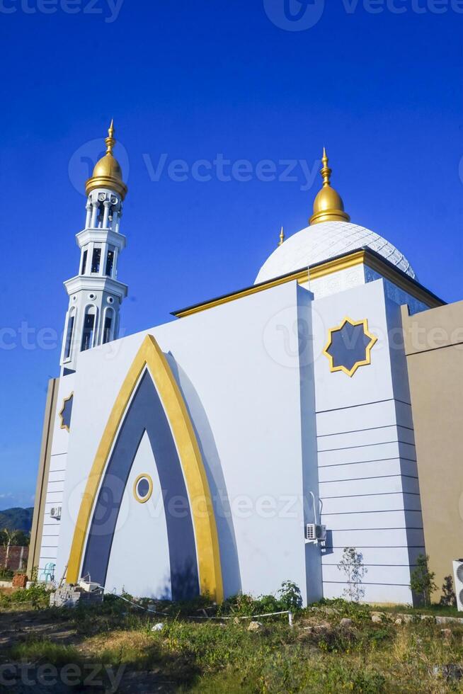 The splendor of the mosque and its towering minaret under the blue sky creates a stunning view photo
