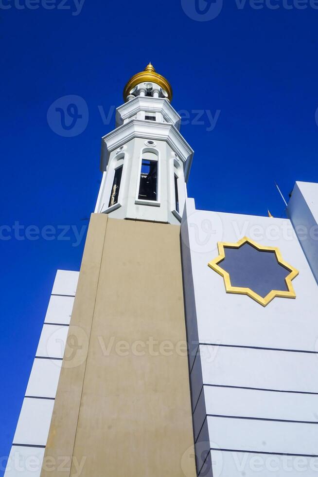 The splendor of the mosque and its towering minaret under the blue sky creates a stunning view photo