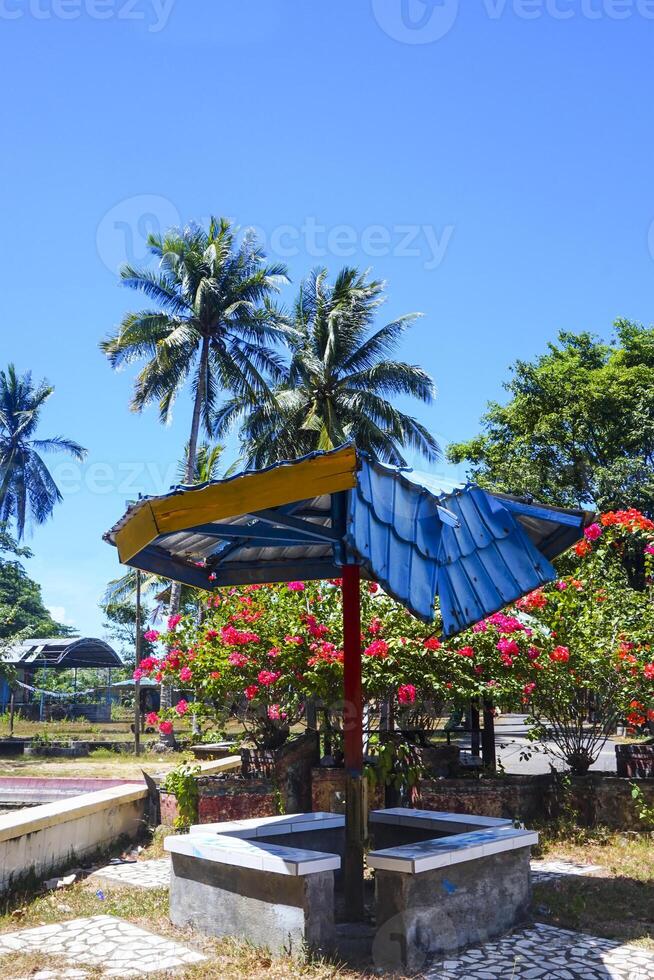 garden view with green grass and gazebo during the day with a blue background photo