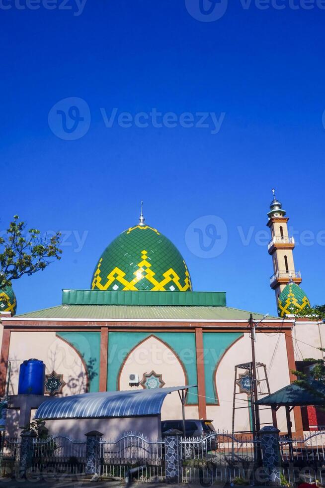 The splendor of the mosque and its towering minaret under the blue sky creates a stunning view photo