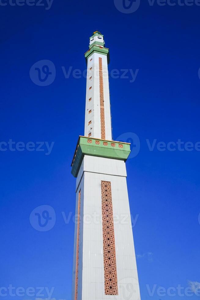 view of the mosque tower soaring high, against a blue sky photo