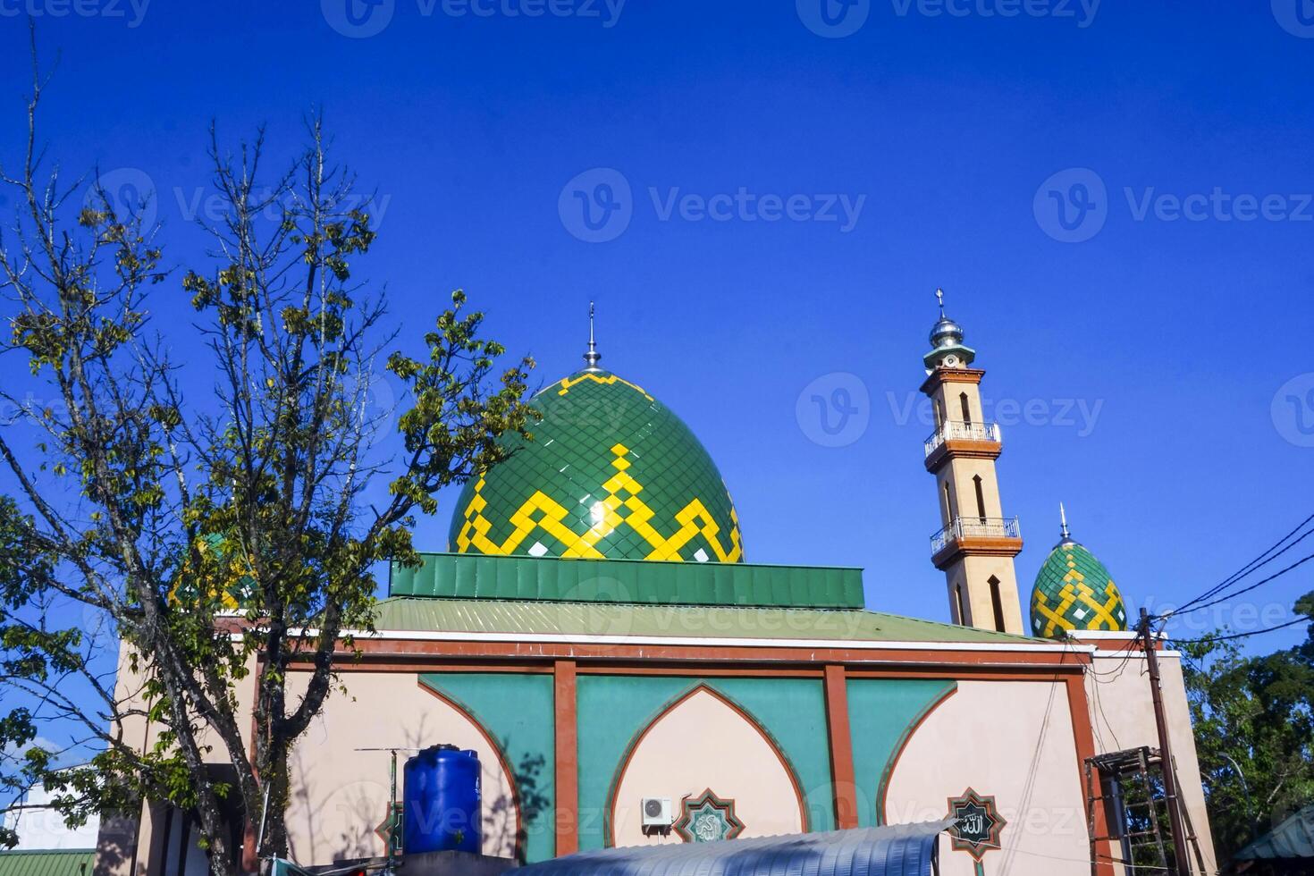 The splendor of the mosque and its towering minaret under the blue sky creates a stunning view photo