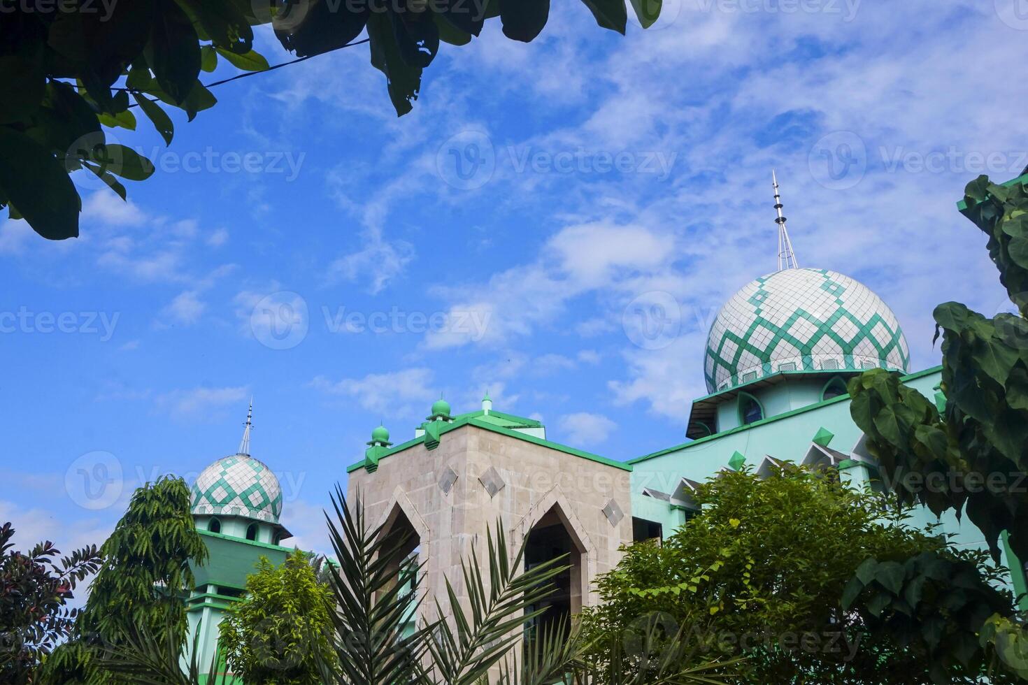 The Grand Mosque of Maros is blue with a large dome, set against a blue sky photo