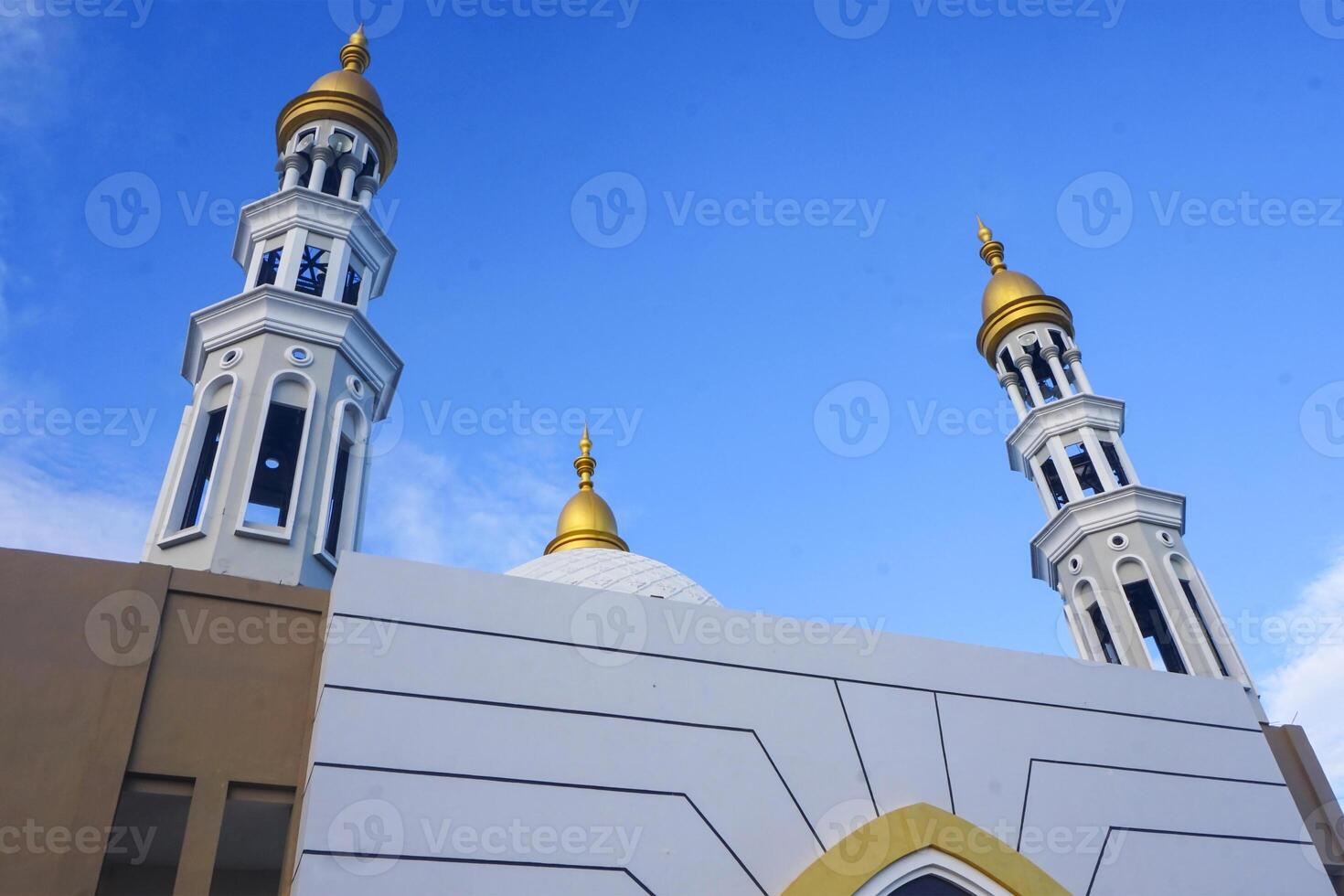 The splendor of the mosque and its towering minaret under the blue sky creates a stunning view photo