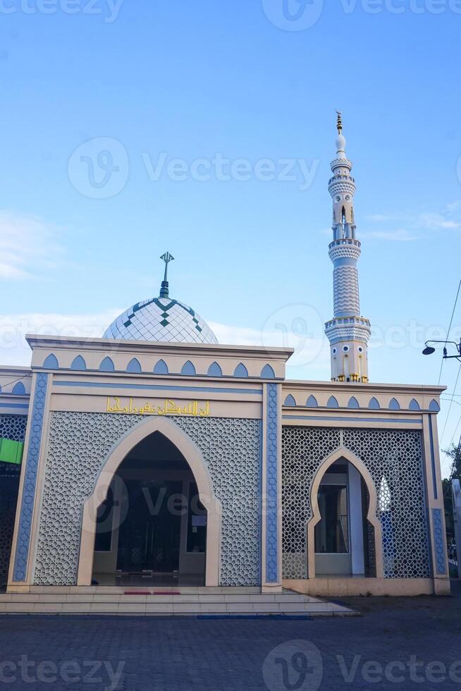 The splendor of the mosque and its towering minaret under the blue sky creates a stunning view photo