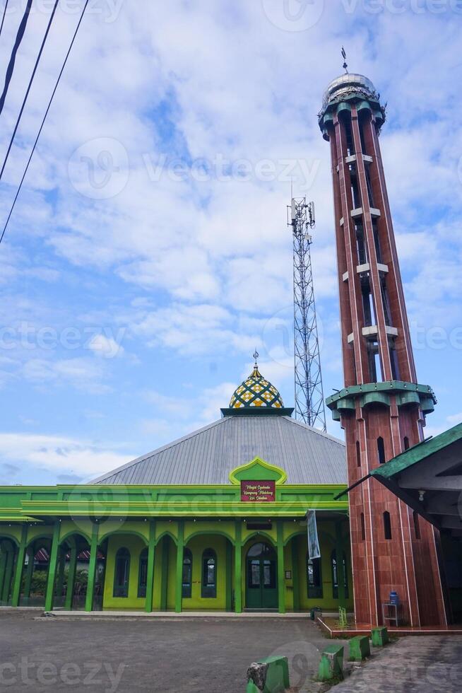 The splendor of the mosque and its towering minaret under the blue sky creates a stunning view photo