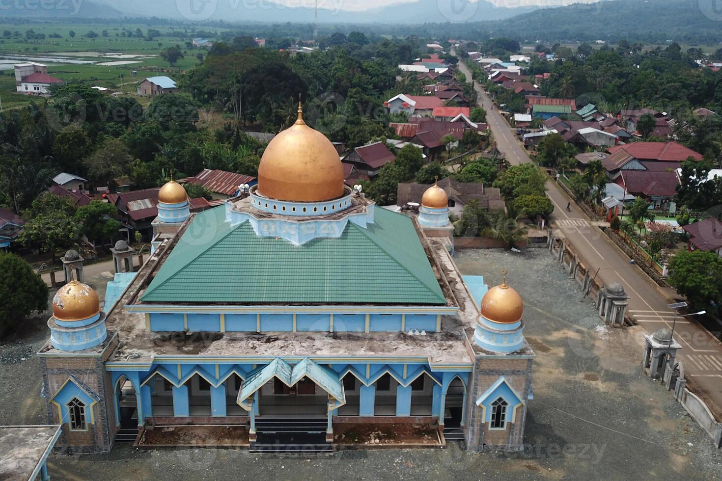panorama of the mosque in the middle of the countryside with a backdrop of sky and mountains photo