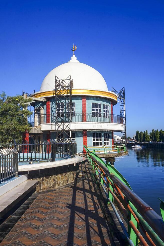 The view of a mosque beside a river in an urban area adds to the impression of peace photo
