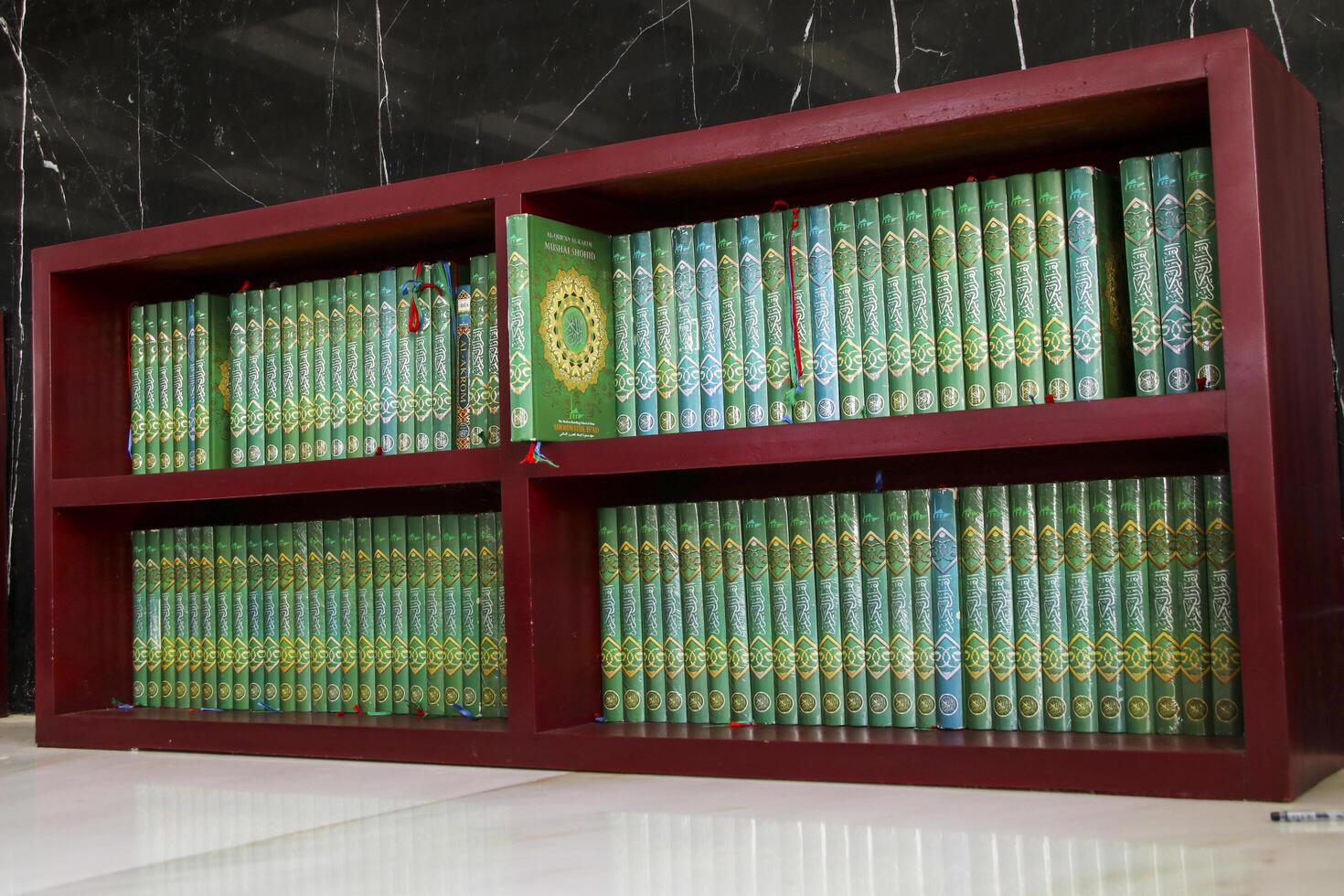 Pangkep, Indonesia, March 15 2023. The Koran is neatly arranged on a wooden shelf, the holy book of the Muslim ummah photo
