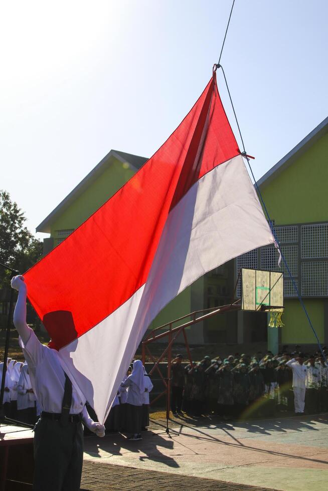 Pangkep, Indonesia, March 15 2023. Indonesia's red and white flag fluttered as students were pulling a ceremony photo