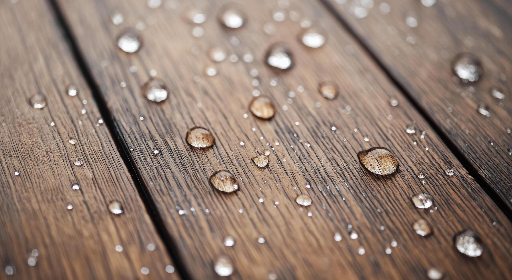 Water droplets resting on textured wooden surface after rainfall photo