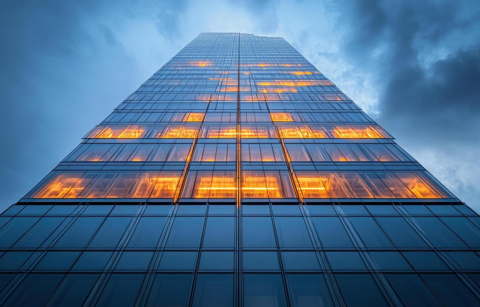 Modern glass building illuminated at dusk in an urban setting photo
