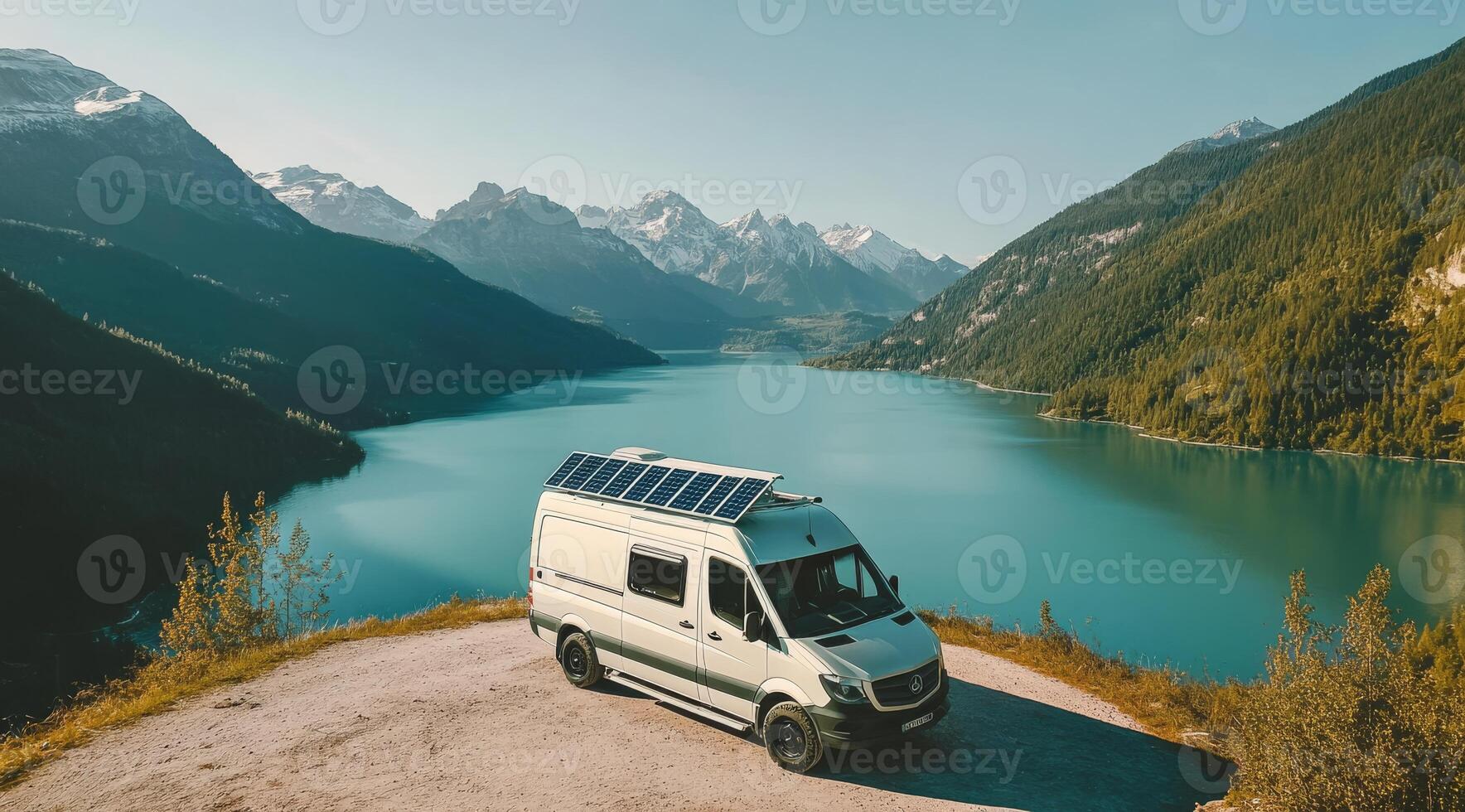 A beautifully designed campervan with an energyefficient solar panel is parked by a tranquil lake, surrounded by majestic mountains, representing sustainable travel and exploration in nature photo